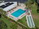 Aerial view of pool with lounge chairs, shuffle board, and tropical landscaping at 2616 Cove Cay Dr # 803, Clearwater, FL 33760
