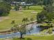 Aerial view of the pond and golf course featuring sand traps, water lillies, and palms at 2616 Cove Cay Dr # 803, Clearwater, FL 33760