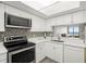 Clean kitchen with new appliances, stone countertops, white cabinetry, and mosaic backsplash with pass through at 2616 Cove Cay Dr # 803, Clearwater, FL 33760