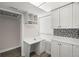 Small kitchenette area with white cabinets, light countertop, storage cubbies, and a window with blinds at 2616 Cove Cay Dr # 803, Clearwater, FL 33760