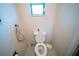 Half bathroom features a white toilet, tile flooring, and a window with mini blinds at 2780 E Sam Allen Rd, Plant City, FL 33565