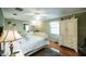 Cozy bedroom with hardwood floors, light green walls, and a white ceiling fan at 2780 E Sam Allen Rd, Plant City, FL 33565