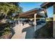 Carport with a concrete floor, a grill and three parked vehicles at 2780 E Sam Allen Rd, Plant City, FL 33565