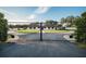 Secure iron gates open to reveal a charming single-story home with lush landscaping and a long driveway at 2780 E Sam Allen Rd, Plant City, FL 33565