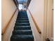 Carpeted stairs featuring wooden handrails, leading up to the next level of the home at 2780 E Sam Allen Rd, Plant City, FL 33565