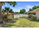Manicured backyard with lush green grass, mature trees, and a charming white picket fence at 31076 Castle Ridge Drive, Brooksville, FL 34602