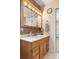 Bathroom vanity featuring wood cabinets, large mirror with lighting, and a white countertop at 31076 Castle Ridge Drive, Brooksville, FL 34602