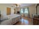 Cozy bedroom with wood-look floors, ceiling fan, natural light, and comfortable bed at 31076 Castle Ridge Drive, Brooksville, FL 34602