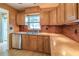 Kitchen features wood cabinets, tile backsplash, stainless steel dishwasher, and a double stainless sink at 31076 Castle Ridge Drive, Brooksville, FL 34602