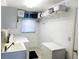 Efficient laundry room equipped with a sink, washer, dryer, and ample storage space at 31076 Castle Ridge Drive, Brooksville, FL 34602