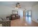 Bright living room features wood-look flooring, ceiling fans, leather sofa, and sliding glass door access at 31076 Castle Ridge Drive, Brooksville, FL 34602