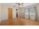 Bright main bedroom featuring laminate floors, a ceiling fan, and large windows at 31076 Castle Ridge Drive, Brooksville, FL 34602