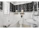 Stylish bathroom featuring black and white patterned wallpaper, white subway tile, and vintage-style fixtures at 321 Brightwaters Ne Blvd, St Petersburg, FL 33704