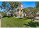 Stunning two-story home featuring a lush green lawn, architectural tower, and elegant exterior design with arched windows at 321 Brightwaters Ne Blvd, St Petersburg, FL 33704