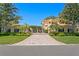 Grand estate featuring manicured lawns, palm trees and a gated entry with a brick driveway leading to the residence at 321 Brightwaters Ne Blvd, St Petersburg, FL 33704