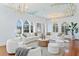 Elegant living room featuring hardwood floors, a decorative ceiling, chandeliers, and views through the windows at 321 Brightwaters Ne Blvd, St Petersburg, FL 33704