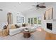 Elegant living room featuring a fireplace, hardwood floors, and access to the outdoor pool area at 321 Brightwaters Ne Blvd, St Petersburg, FL 33704