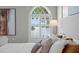 Comfortable bedroom showcases water view through arched window, complemented by plush bedding and stylish decor at 321 Brightwaters Ne Blvd, St Petersburg, FL 33704