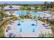 Aerial view of a community pool, splashpad, and lounge area with palm trees at 32111 Brookstone Dr, Wesley Chapel, FL 33545