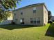 Backyard featuring a well-maintained lawn with a sliding door and windows on the home's exterior at 32111 Brookstone Dr, Wesley Chapel, FL 33545