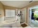 Bright bathroom featuring a soaking tub, separate glass shower, and adjacent closet at 32111 Brookstone Dr, Wesley Chapel, FL 33545