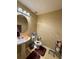 Cozy half bathroom with a pedestal sink, decorative mirror, and soft lighting at 32111 Brookstone Dr, Wesley Chapel, FL 33545