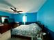 Bedroom featuring blue walls, a ceiling fan, a bed and a dresser at 32111 Brookstone Dr, Wesley Chapel, FL 33545