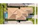Aerial view of home featuring tile roof, pool, manicured lawn, and driveway with parked car at 32324 Rosewood Meadow Ln, Wesley Chapel, FL 33543