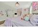 Charming bedroom featuring two twin beds and decorative cherry tree and wall art at 32324 Rosewood Meadow Ln, Wesley Chapel, FL 33543