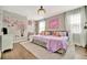 Charming bedroom featuring two twin beds, hardwood floors, and bright natural lighting at 32324 Rosewood Meadow Ln, Wesley Chapel, FL 33543