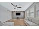 Bonus room with hardwood floors, a ceiling fan, a wall-mounted TV, and a comfortable sectional sofa at 32324 Rosewood Meadow Ln, Wesley Chapel, FL 33543