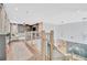 Hallway overlooking living room boasts hardwood floors and modern finishes at 32324 Rosewood Meadow Ln, Wesley Chapel, FL 33543