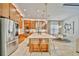 Spacious kitchen with stainless steel appliances, an island with counter seating, and a view of the adjacent dining area at 32324 Rosewood Meadow Ln, Wesley Chapel, FL 33543