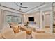 Bright living room with comfortable seating, a large TV, and sliding glass doors leading to an outdoor area at 32324 Rosewood Meadow Ln, Wesley Chapel, FL 33543