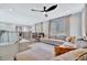 Spacious living room featuring an open staircase, built-in bookshelves, a large sectional, and hardwood floors at 32324 Rosewood Meadow Ln, Wesley Chapel, FL 33543