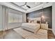 Main bedroom featuring a textured accent wall, tray ceiling, and stylish pendant lighting at 32324 Rosewood Meadow Ln, Wesley Chapel, FL 33543