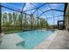 Screened pool with water features, patio, black metal fence, and picturesque views at 32324 Rosewood Meadow Ln, Wesley Chapel, FL 33543