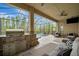 Screened pool area with outdoor kitchen, ceiling fans, ample seating, and scenic views at 32324 Rosewood Meadow Ln, Wesley Chapel, FL 33543