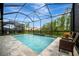 Screened pool with water features, patio, black metal fence, and picturesque views at 32324 Rosewood Meadow Ln, Wesley Chapel, FL 33543