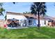 Well-maintained backyard featuring a covered patio, palm tree, and green lawn at 3238 6Th W Ave, Palmetto, FL 34221