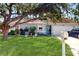 Charming single-story home with a beautiful lawn, mature tree, and a welcoming turquoise front door at 3238 6Th W Ave, Palmetto, FL 34221