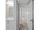 Bright bathroom adjacent to hallway, featuring stylish vanity with marble counters at 3706 Greenery Ct # 206, Tampa, FL 33618