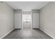 Bedroom with gray wood-look vinyl flooring, window with blinds, and large closets at 3706 Greenery Ct # 206, Tampa, FL 33618