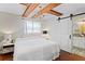Tastefully designed bedroom featuring wood beam ceilings, a chandelier and an attached bathroom with barn door entrance at 4003 W Lemon St, Tampa, FL 33609