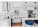 Modern kitchen features stainless steel appliances, white cabinetry, quartz counters, subway tile backsplash, and a breakfast bar island at 4003 W Lemon St, Tampa, FL 33609
