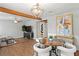 Open-concept area with wood flooring, featuring a dining area and a comfortable living space, with a decorative beam at 4003 W Lemon St, Tampa, FL 33609