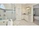 Bright bathroom showcasing a glass shower, bathtub, white cabinets, and double sinks at 4612 Netherwood Dr, Tampa, FL 33624