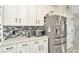 Well-lit kitchen features white cabinets, stainless steel appliances, and mosaic backsplash at 4612 Netherwood Dr, Tampa, FL 33624