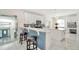 Modern kitchen with white cabinets, tiled backsplash, and a center island with bar stool seating at 4612 Netherwood Dr, Tampa, FL 33624