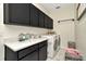 Laundry room featuring sleek dark cabinets, quartz counters, and modern appliances at 4612 Netherwood Dr, Tampa, FL 33624